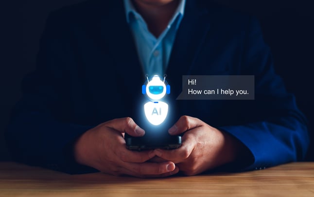 A man holds a phone with a chat AI symbol above it and a prompt reading 