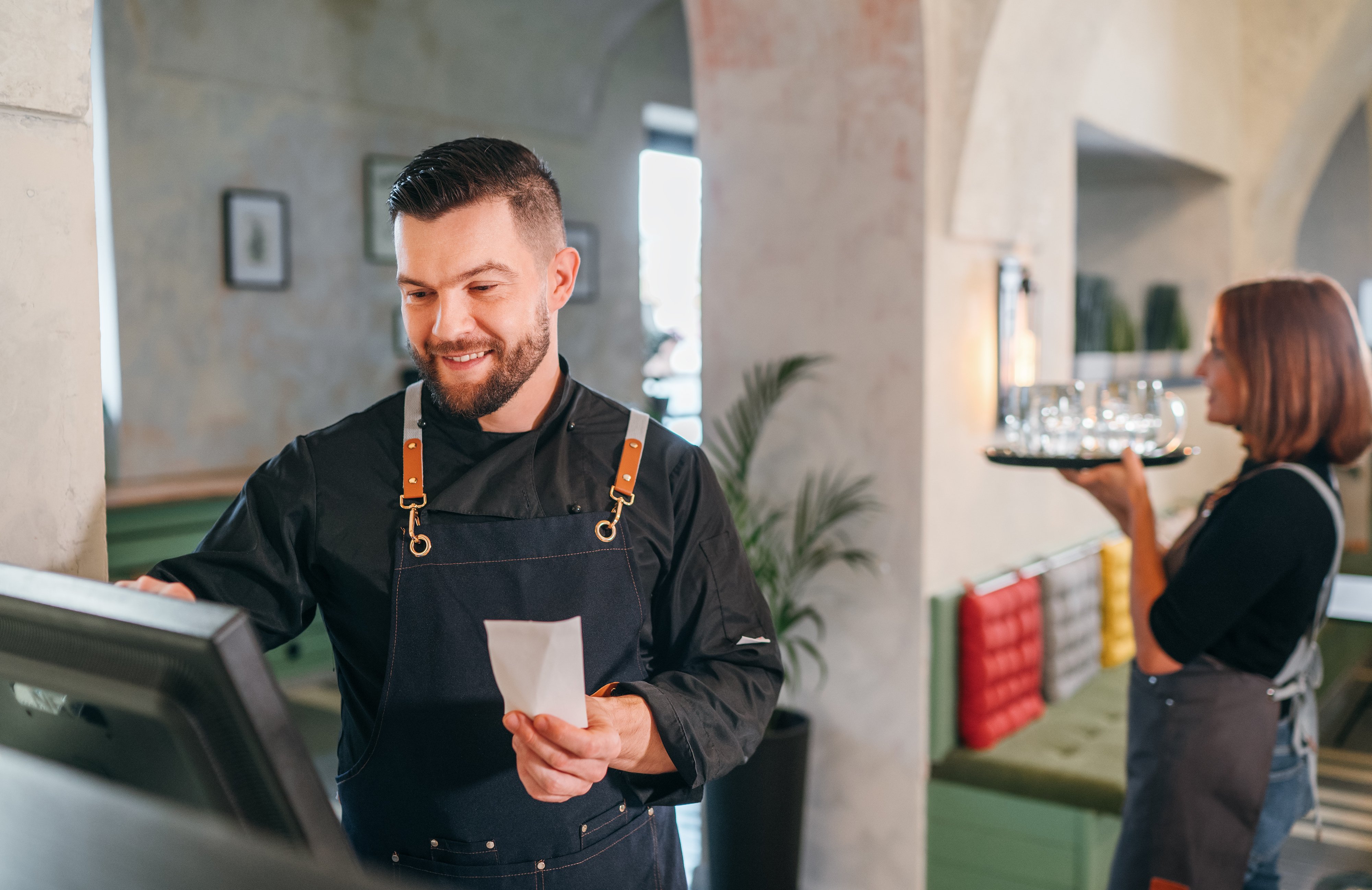 A server enters information into a point of sale terminal. 